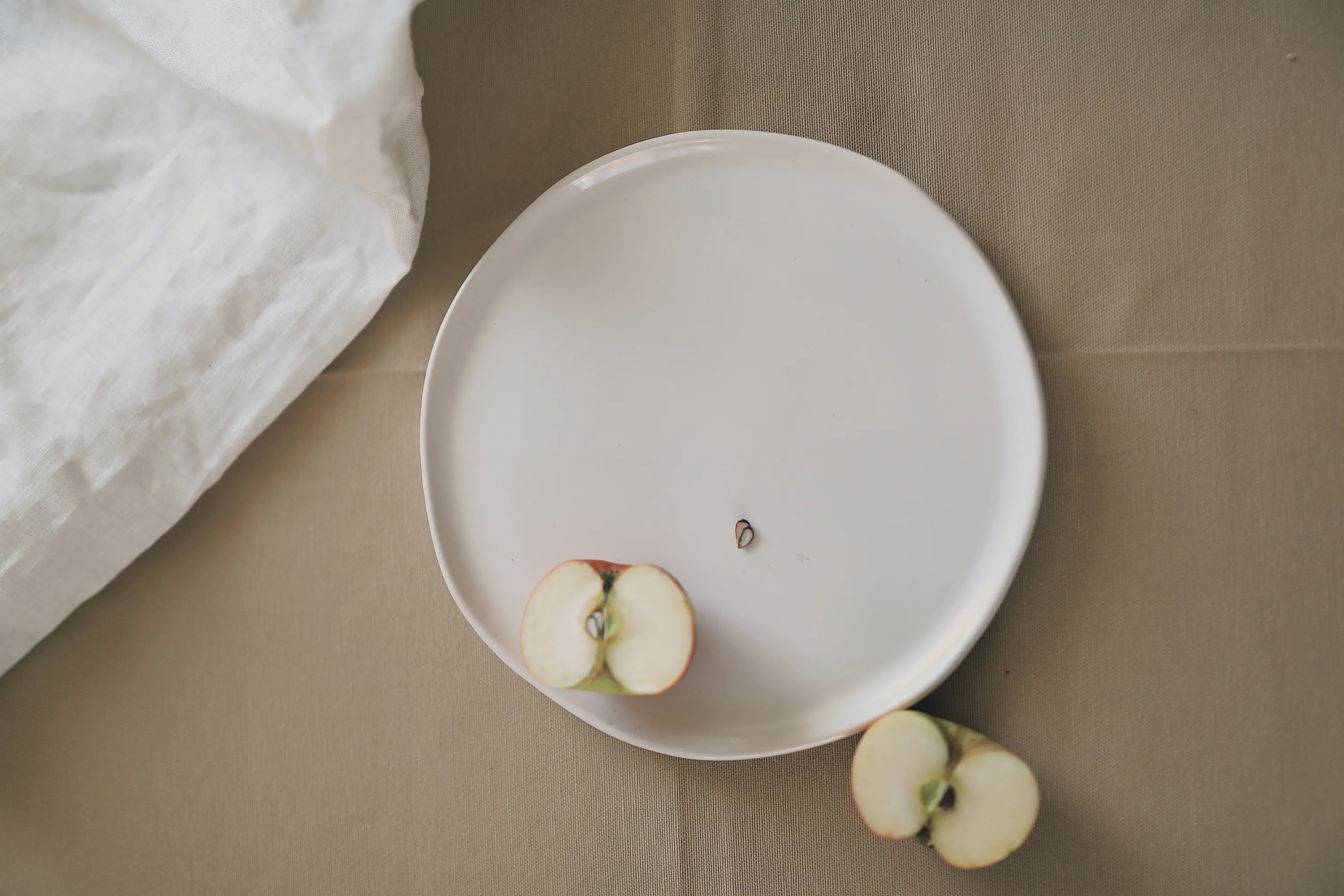 a white plate with two halves of an apple